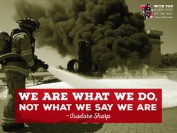 Firefighter spraying foam at an industrial fire with quote &quot;We are what we do, not what we say we are&quot;